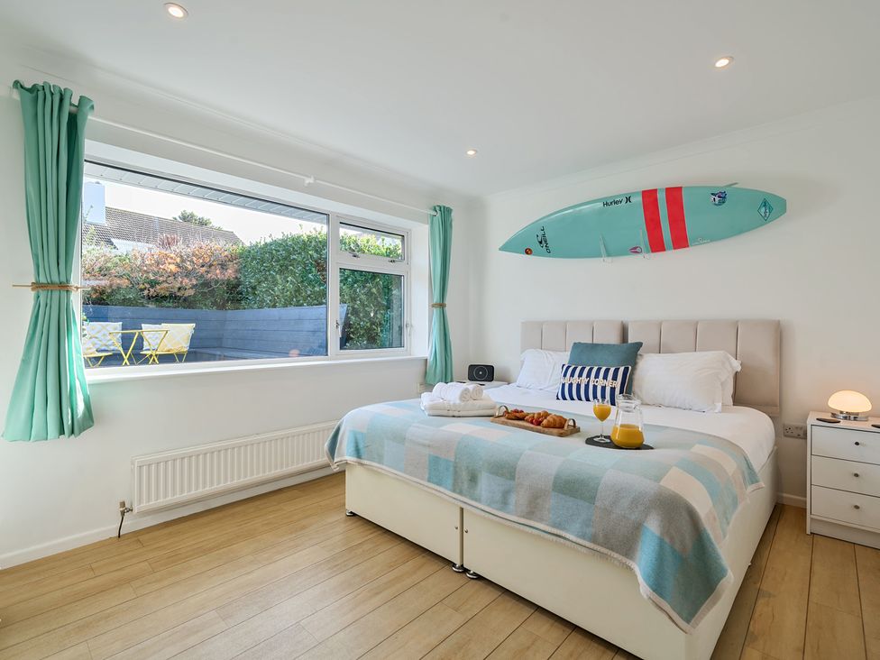 A bedroom with a bed and windows at Sunset View in Porth