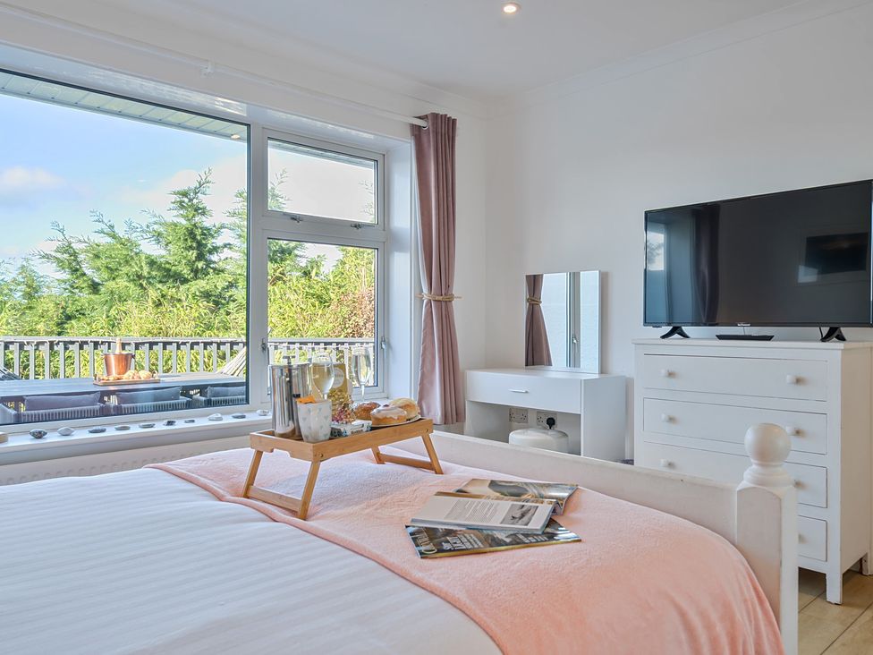 A bedroom with a bed and television at Sunset View in Porth