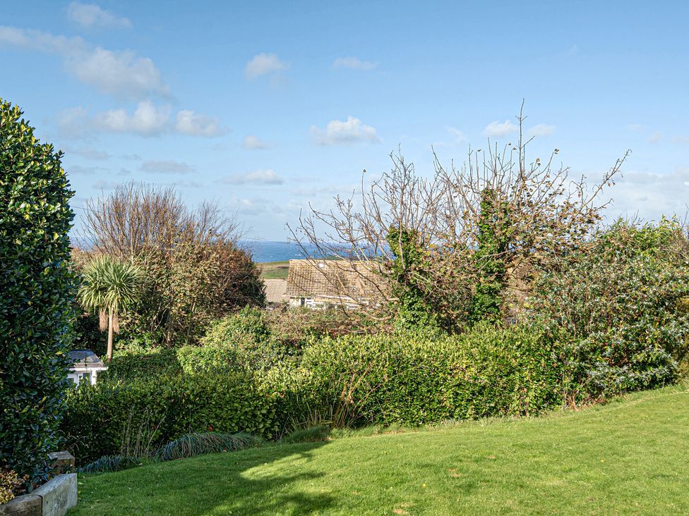 A garden with grass and trees at Sunset View in Porth