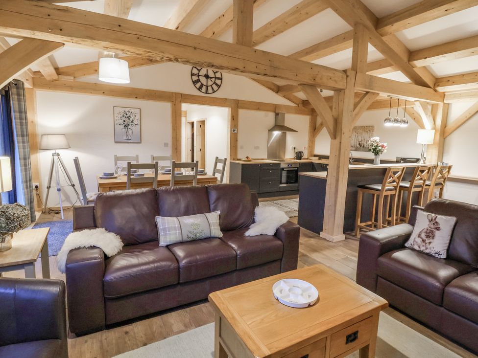 A living room with sofas and a dining table at Lady Bagots Cabin in Ruthin