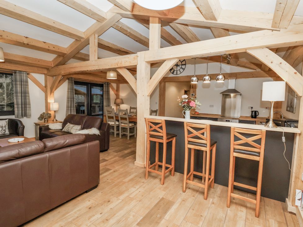 A living room with a sofa and dining area at Lady Bagots Cabin in Ruthin