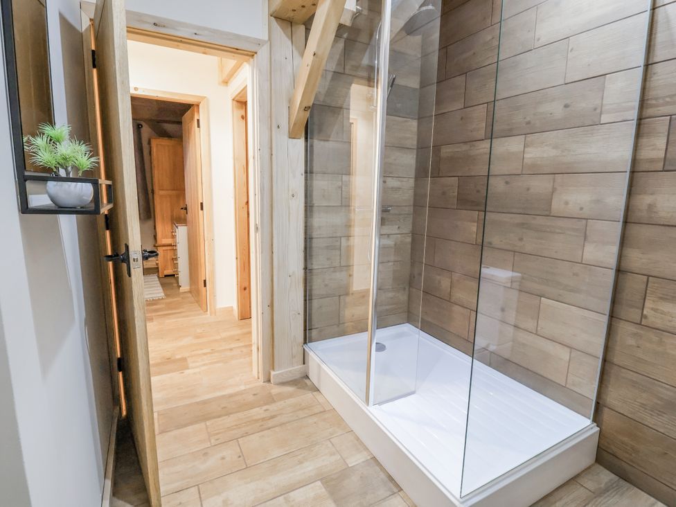 A shower area with glass doors at Lady Bagots Cabin in Ruthin