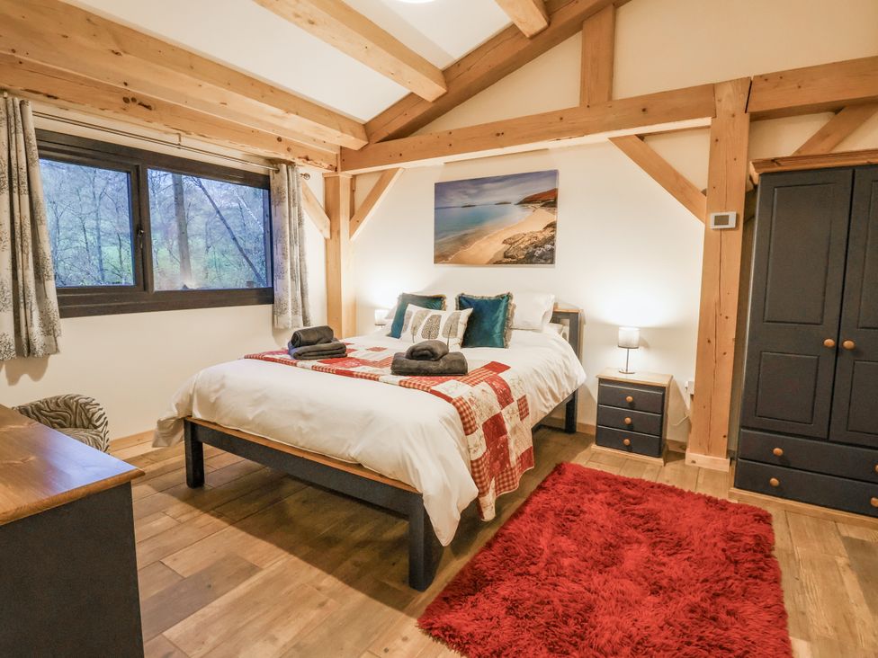 A bedroom with a bed and wardrobe at Lady Bagots Cabin in Ruthin