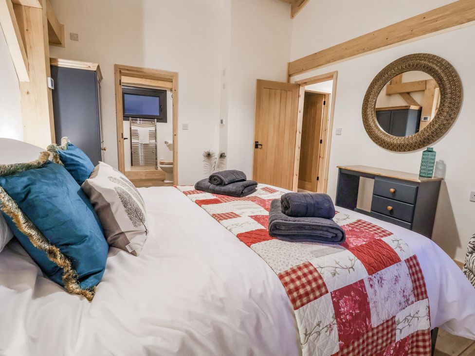 A bedroom with a bed and dresser at Lady Bagots Cabin in Ruthin