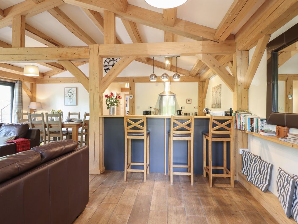 A living room with wooden beams and seating at Lady Bagots Cabin in Ruthin