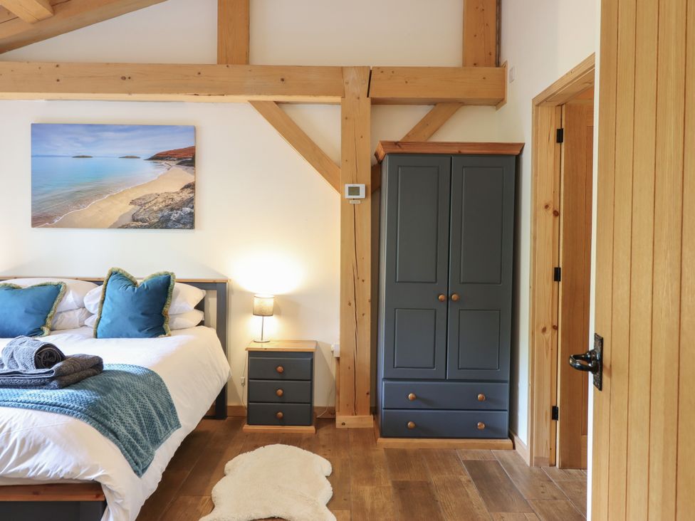 A bedroom with a bed and wardrobe at Lady Bagots Cabin in Ruthin