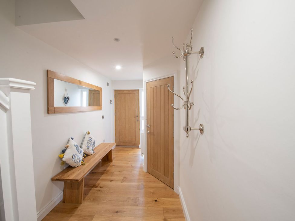 A hallway with a wooden bench and mirror at Harbour Sunset
