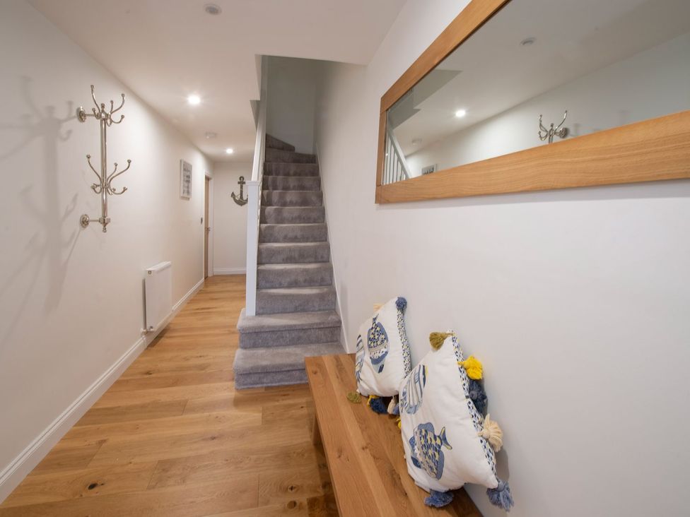 A hallway with a staircase and a wooden bench at Harbour Sunset