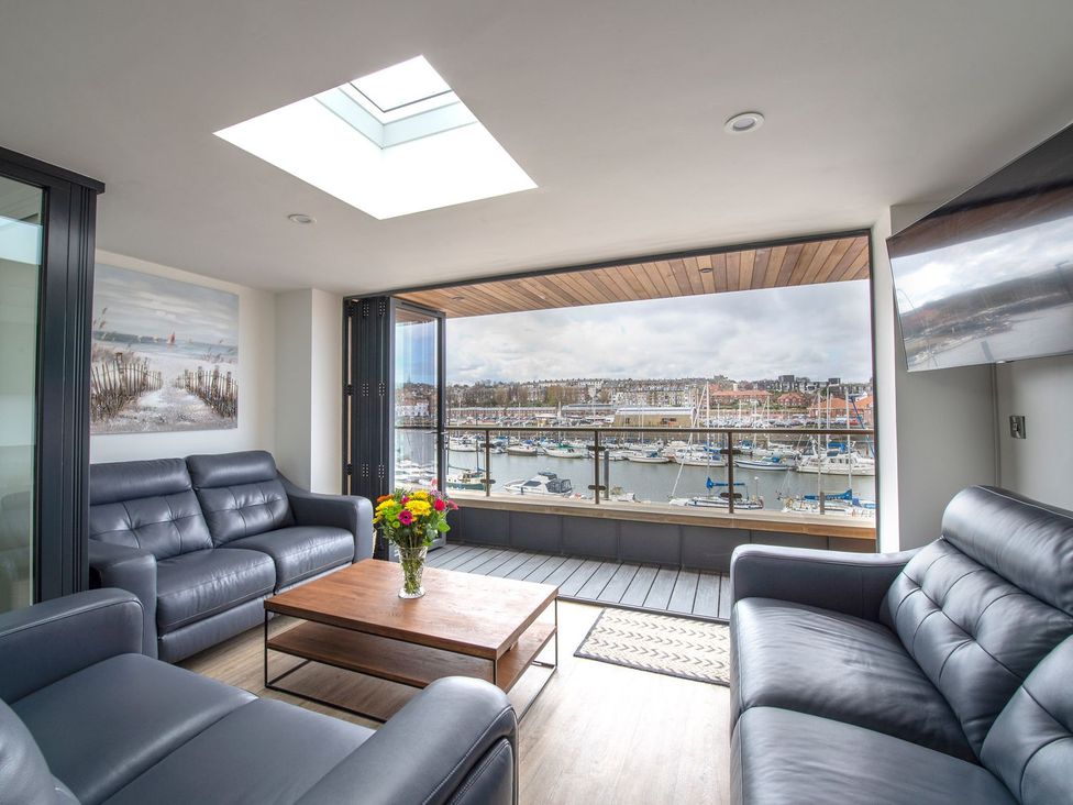 A living room with a view of the marina at Harbour Sunset
