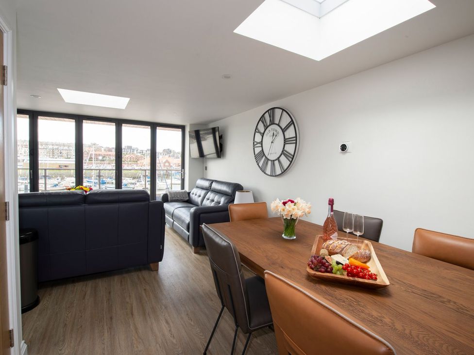 A living room with a table and chairs at Harbour Sunset 