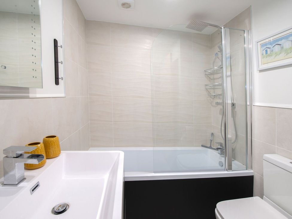 A bathroom with a shower and bath tub at Harbour Sunset