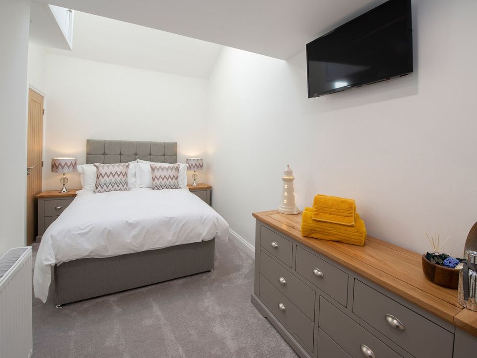 A bedroom with a bed and a television at Harbour Sunset