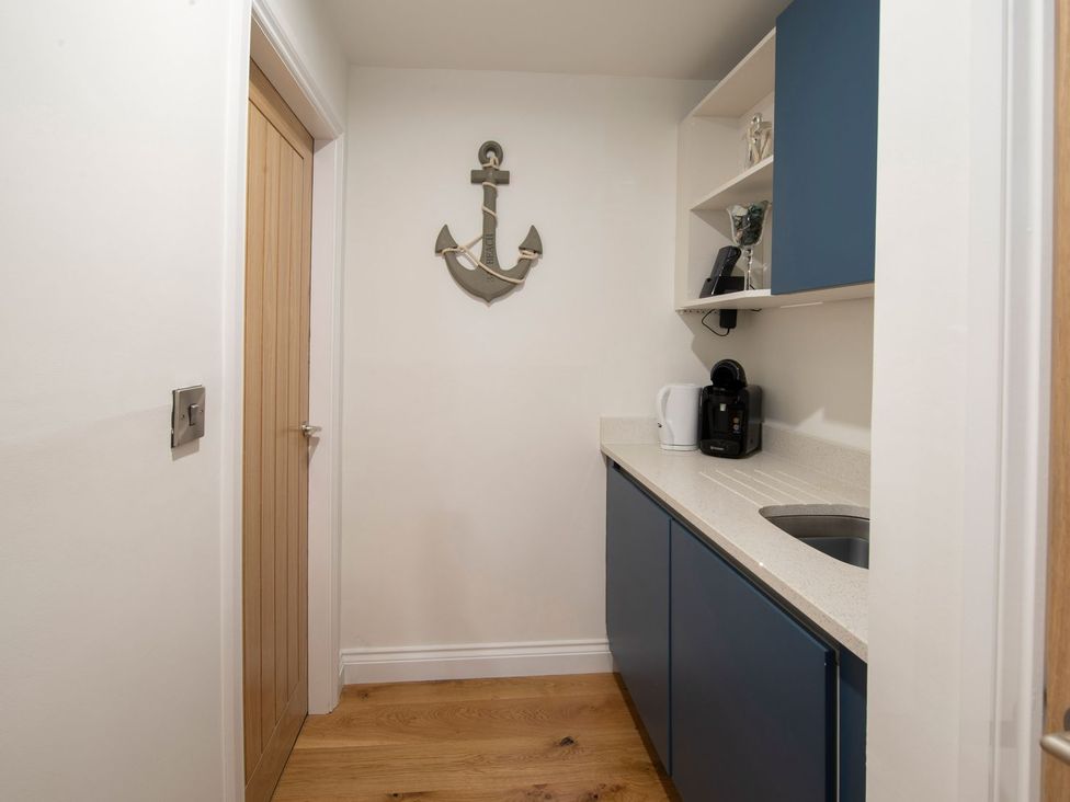 A kitchen with cabinets, a kettle, and a coffee machine at Harbour Sunset in 