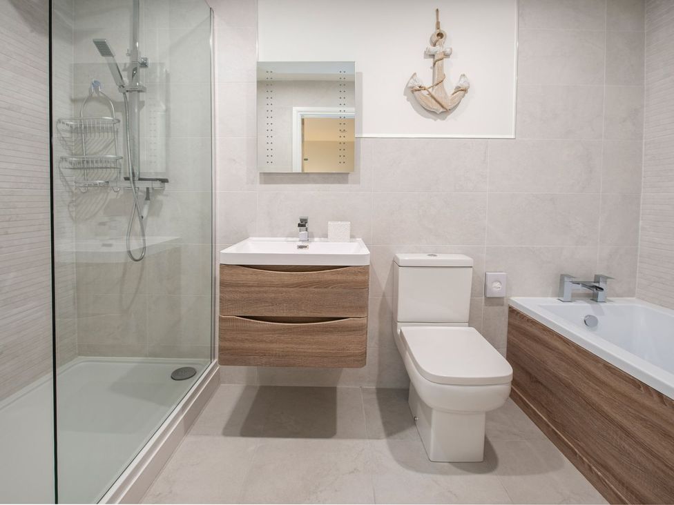 A bathroom with a shower, bath, toilet, and sink at Harbour Sunset