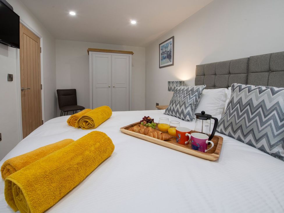 A bedroom with a bed and a tray of breakfast items at Harbour Sunset