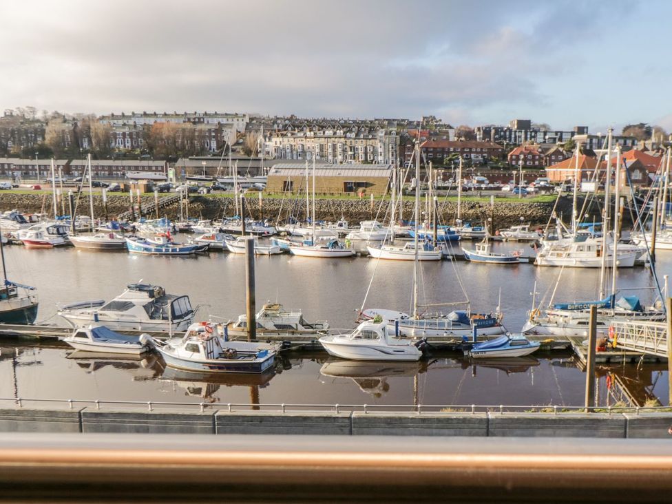 A harbor with boats and buildings in the background at Harbour Sunset in 