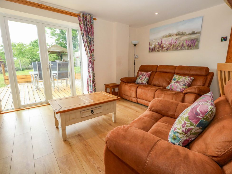 A living room with a sofa and coffee table at Mallows Byre in Yetminster