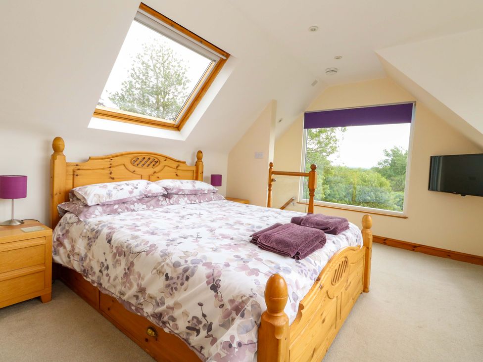 A bedroom with a bed and window at Mallows Byre in Yetminster
