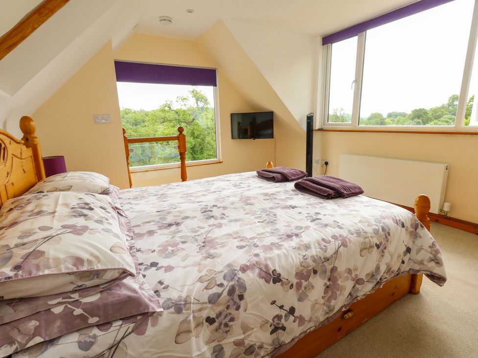 A bedroom with a bed and television at Mallows Byre in Yetminster