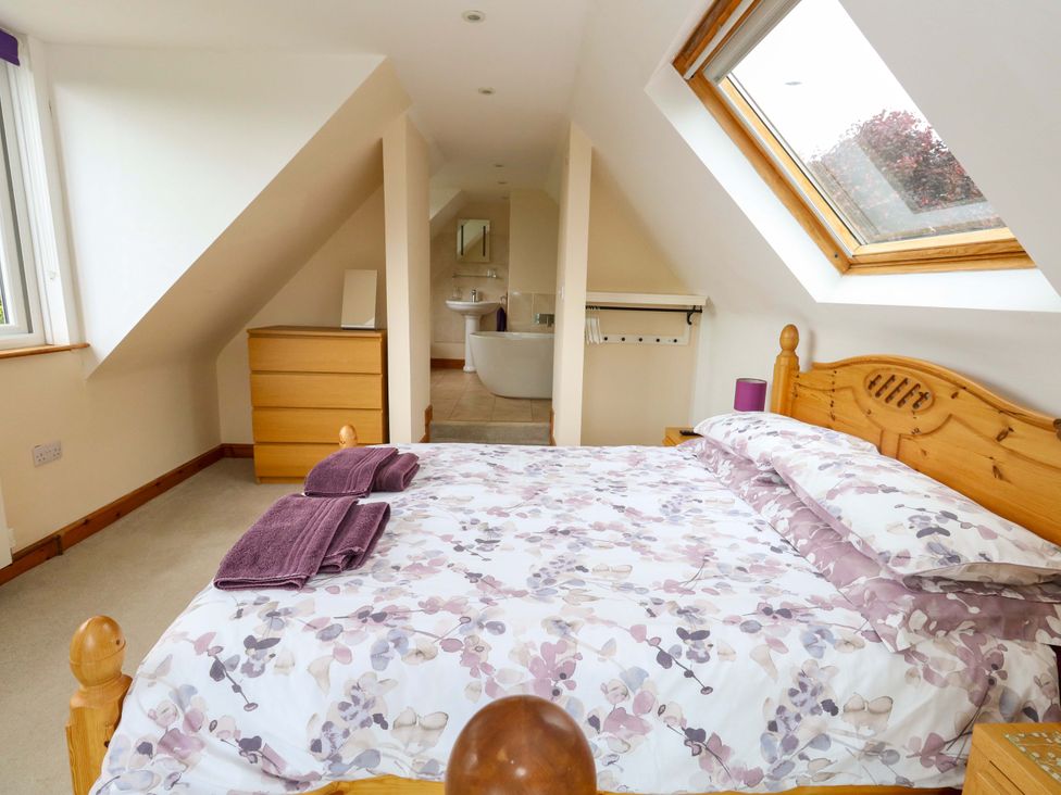 A bedroom with a bed and wardrobe at Mallows Byre in Yetminster