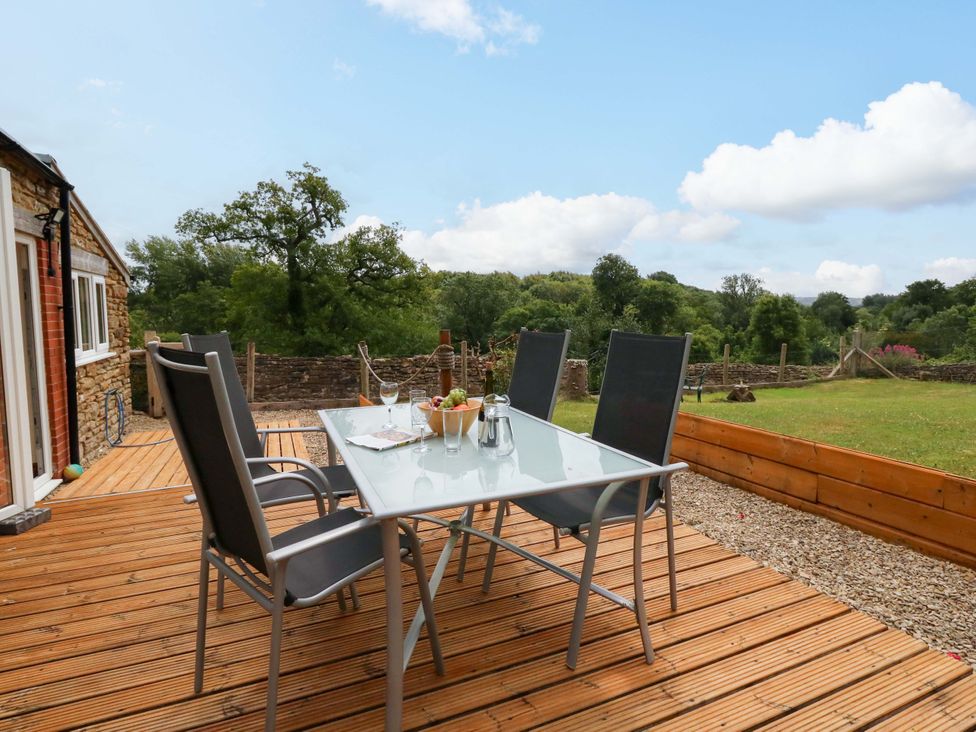 An outdoor area with a table and chairs at Mallows Byre in Yetminster