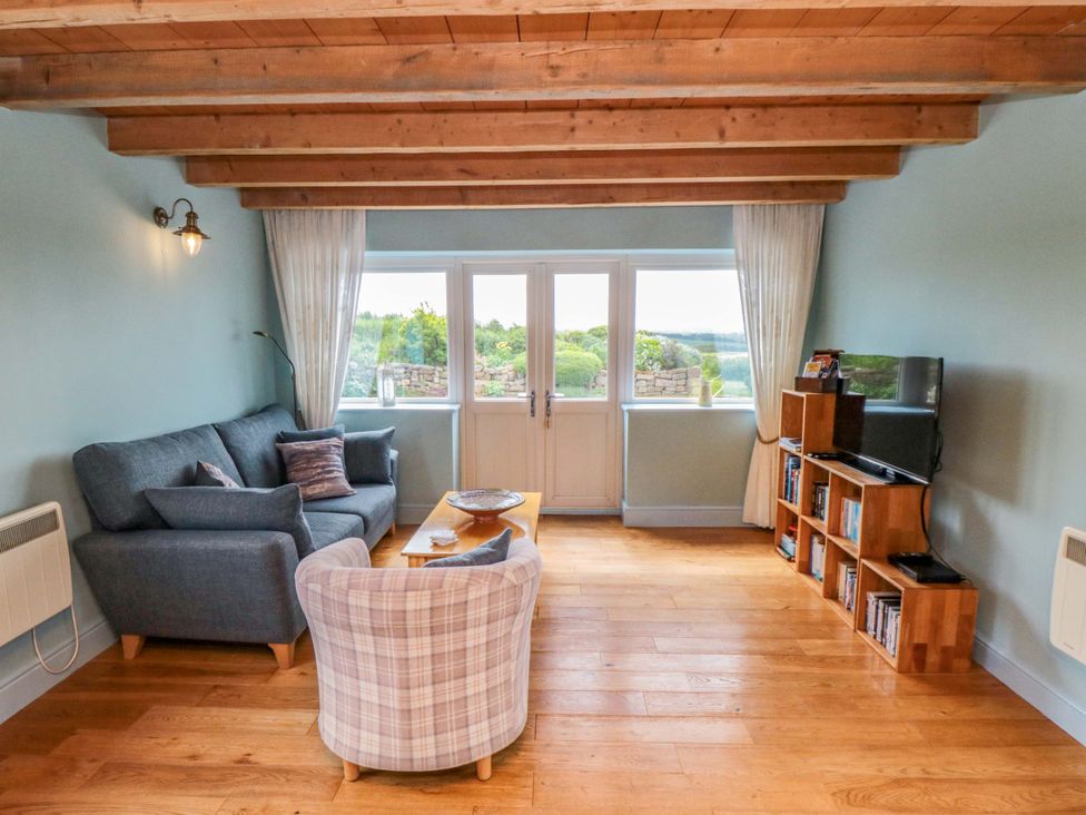 A living room with a sofa and a television at Field Cottage in Staithes