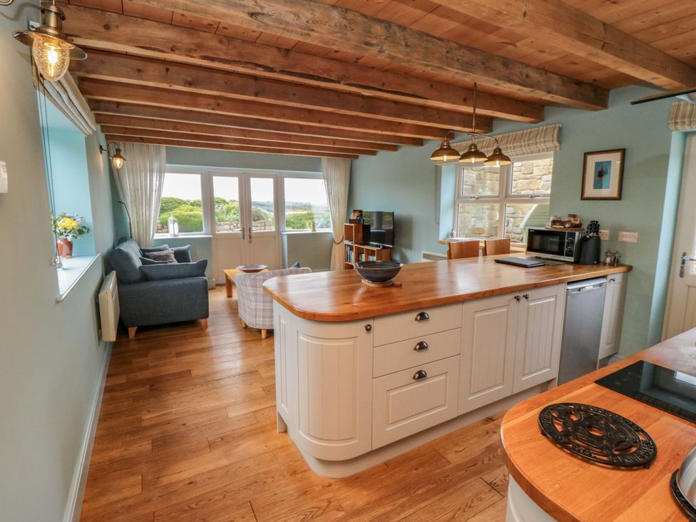 A kitchen with a kitchen island and seating at Field Cottage in Staithes