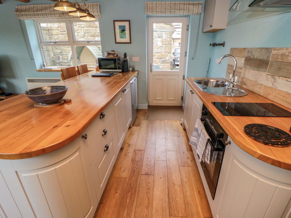 A kitchen with a sink and stove at Field Cottage in Staithes