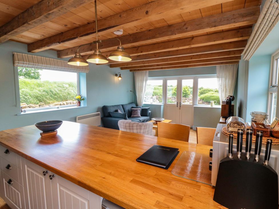 A kitchen with an island and sofa at Field Cottage in Staithes