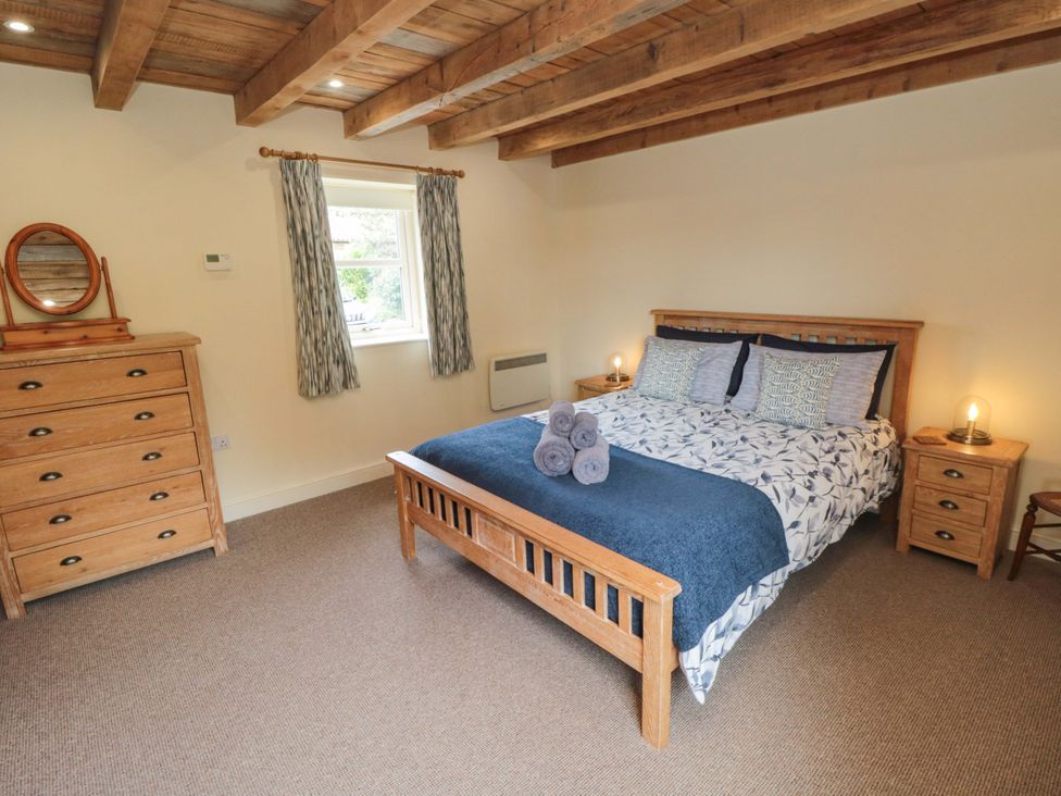 A bedroom with a bed and dresser at Field Cottage in Staithes