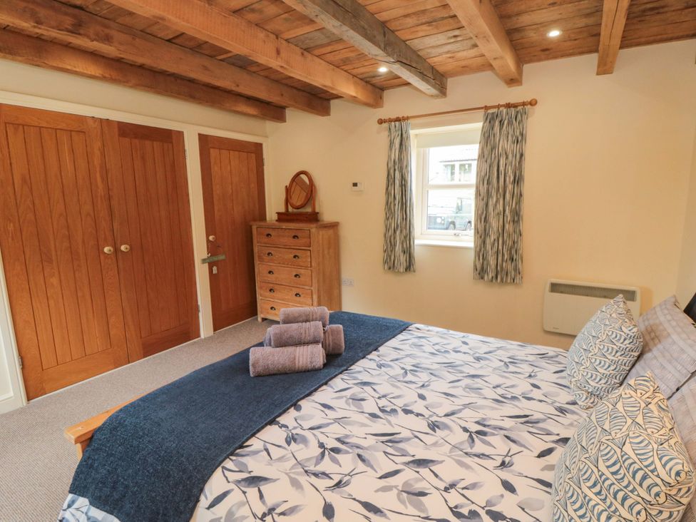 A bedroom with a bed and wardrobe at Field Cottage in Staithes