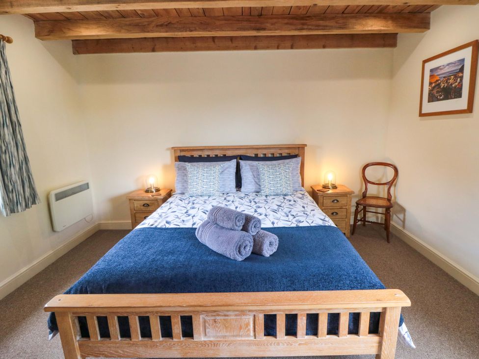 A bedroom with a bed and bedside table at Field Cottage in Staithes