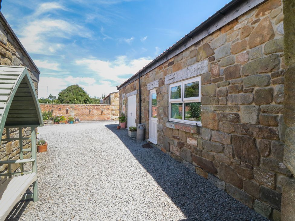An outdoor area with gravel and stone walls at Field Cottage, Staithes