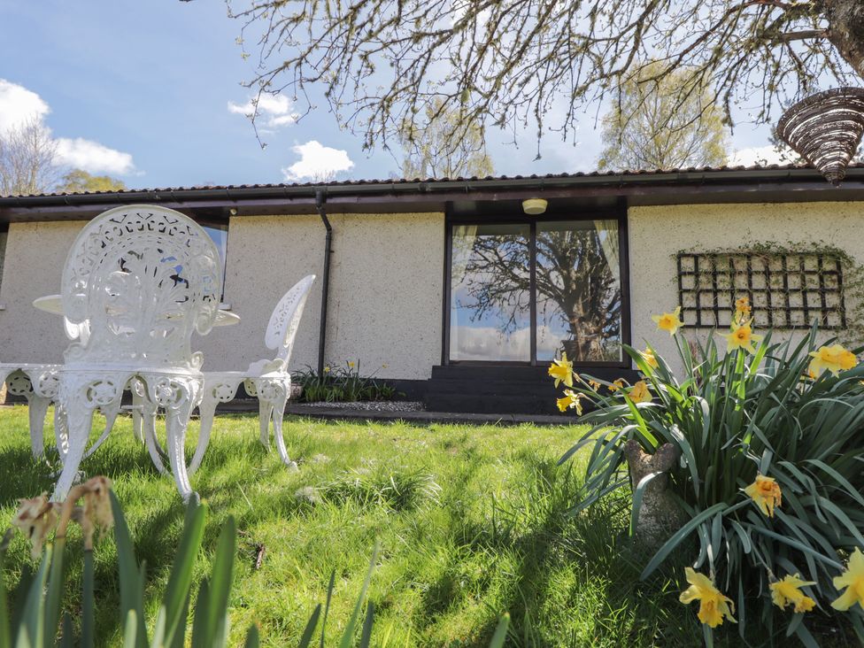 An outdoor area with a chair and table at Strath Glass View at Hill House Cannich