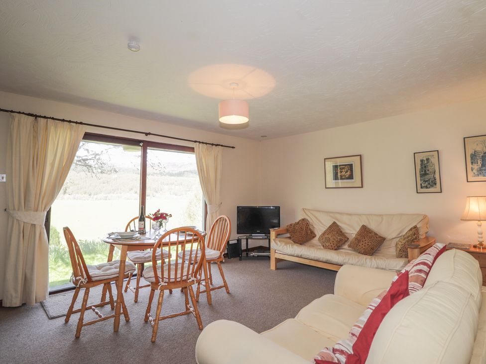 A living room with a dining area and TV at Strath Glass View at Hill House in Cannich