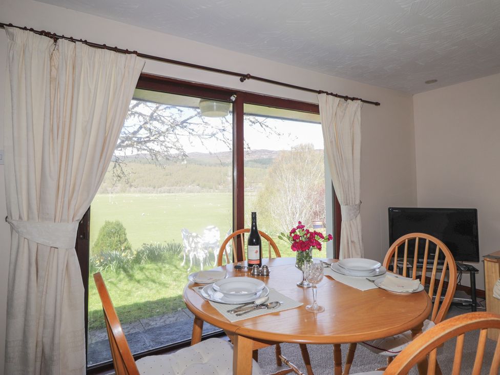 A dining room with a table set for a meal at Strath Glass View at Hill House in Cannich