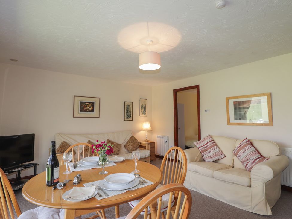 A living room with furniture and dining area at Strath Glass View at Hill House, Cannich