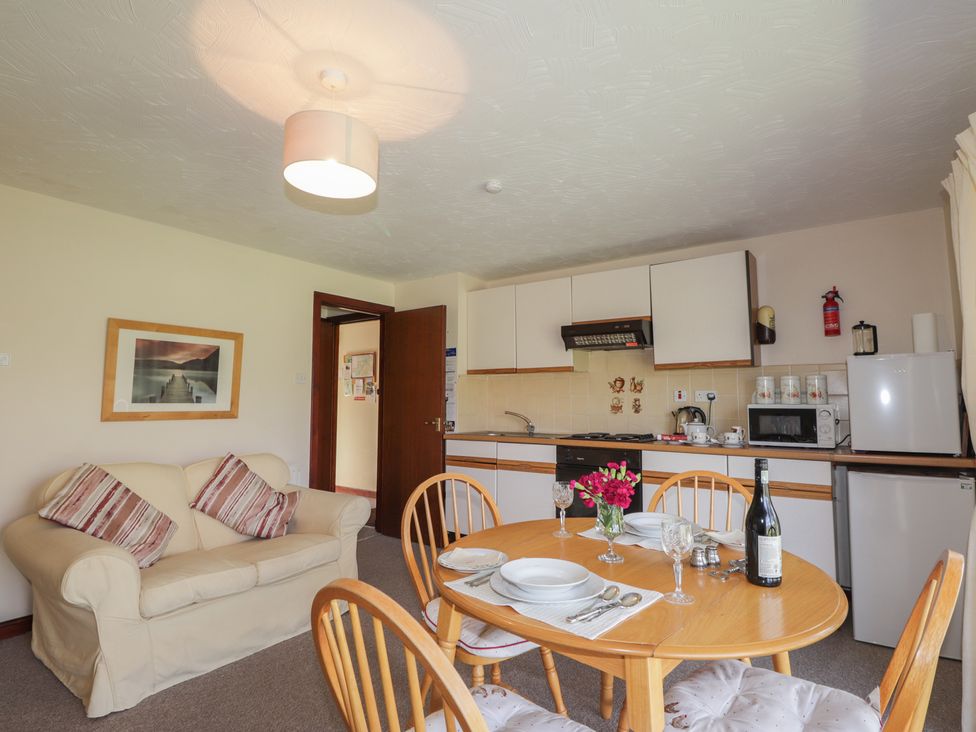 A kitchen with a dining table and sofa at Strath Glass View at Hill House, Cannich