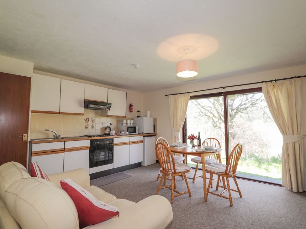 A dining area with a table and chairs at Strath Glass View at Hill House Cannich