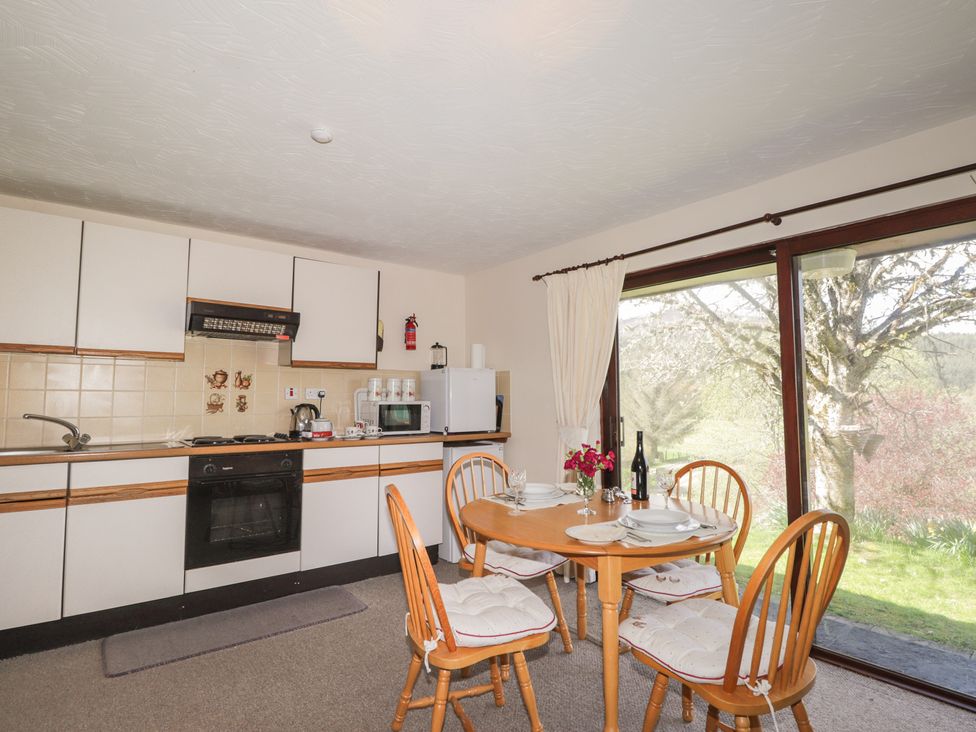 A kitchen with a dining table and chairs at Strath Glass View at Hill House Cannich