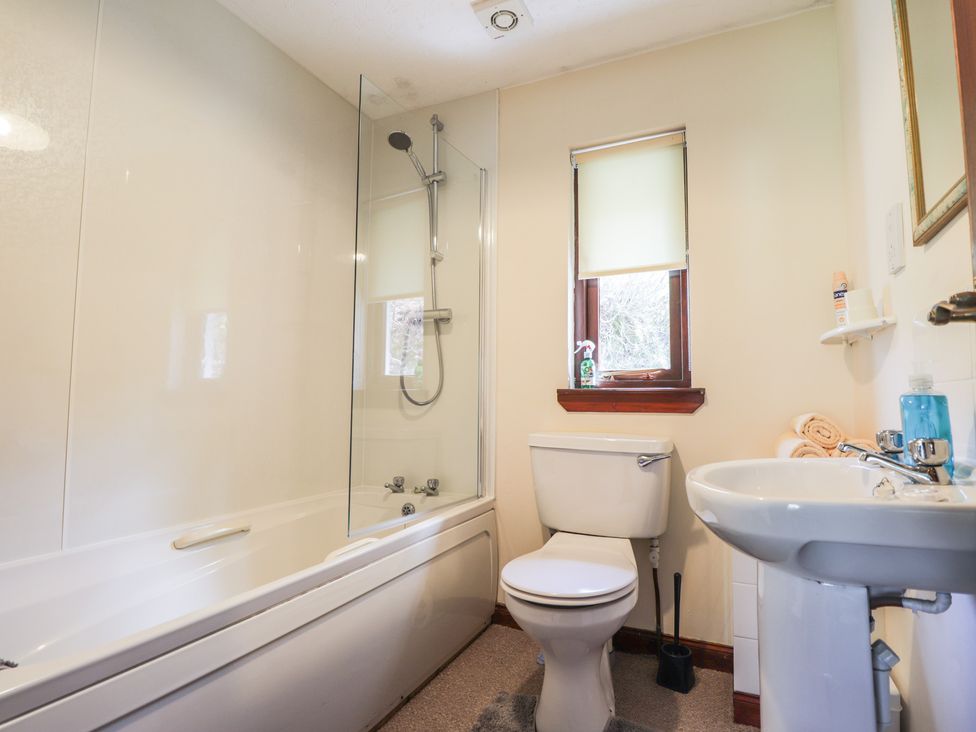 A bathroom with a bathtub, toilet, and sink at Strath Glass View at Hill House Cannich
