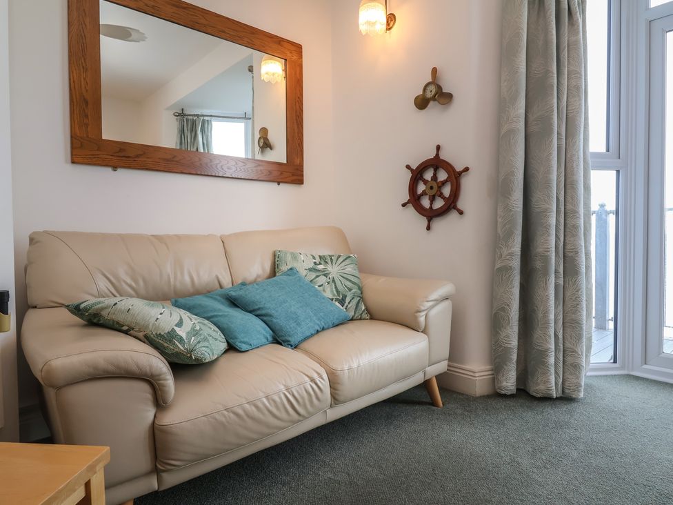 A living room with a sofa and decorative items at Close to Shore