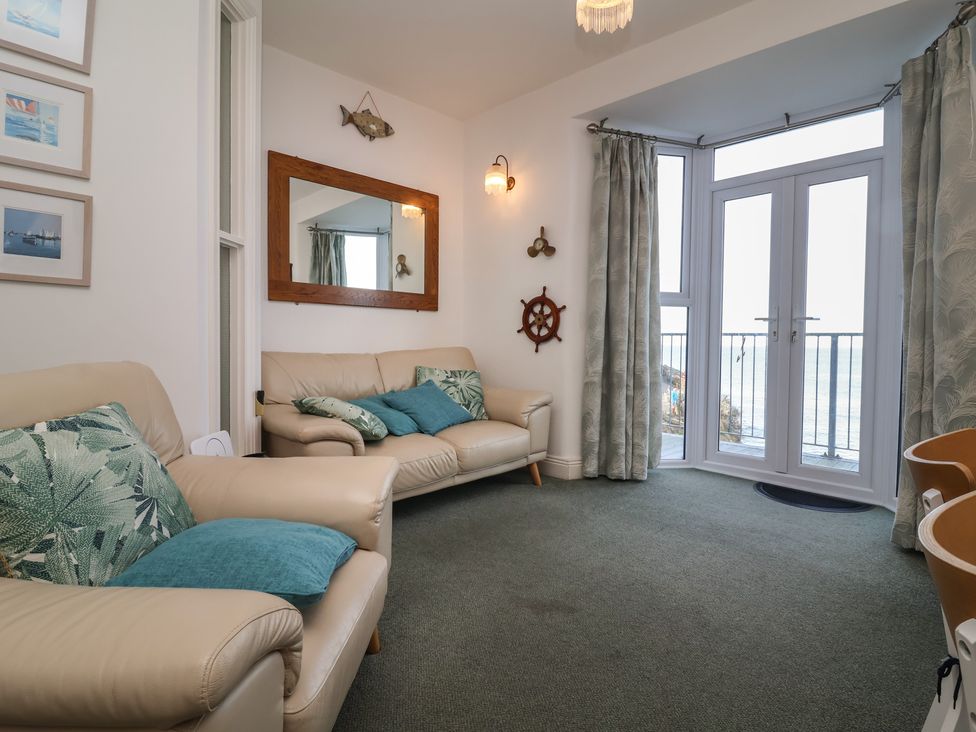 A living room with a glass door and seating at Close to Shore