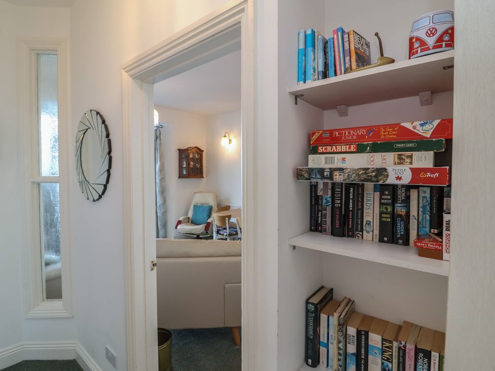 A hallway with a bookcase and a mirror at Close to Shore 
