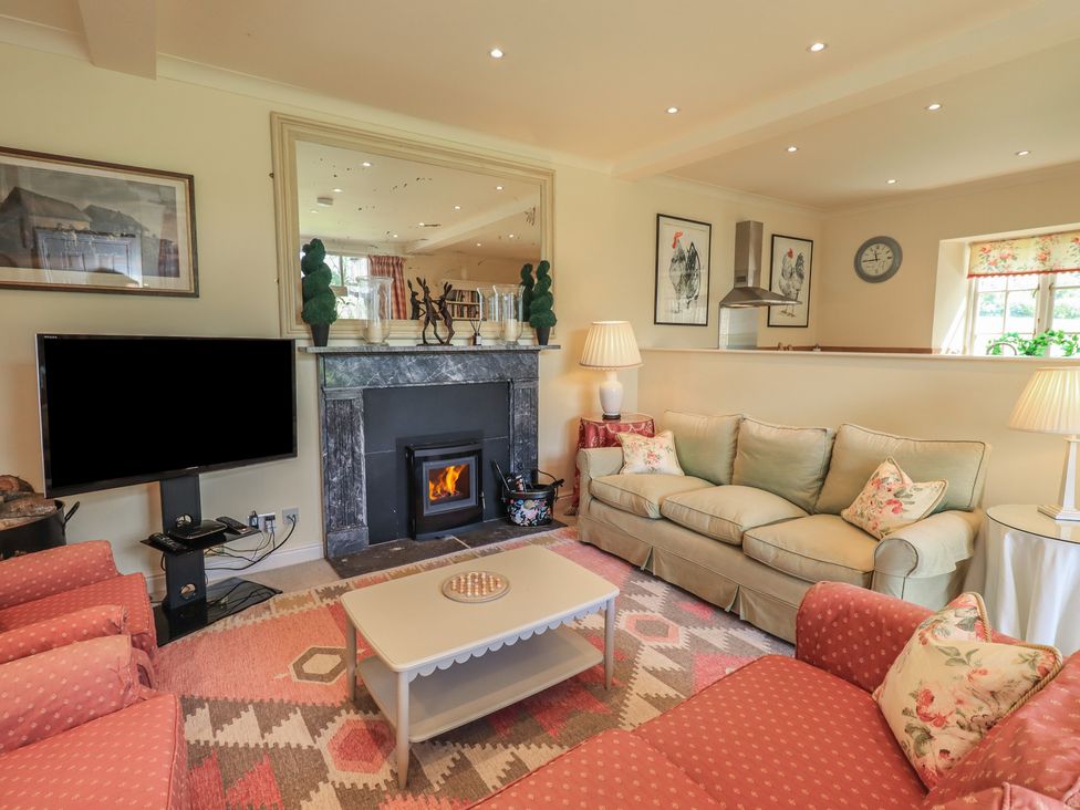 A living room with a television and fireplace at The Garden Rooms Lawkland in Austwick