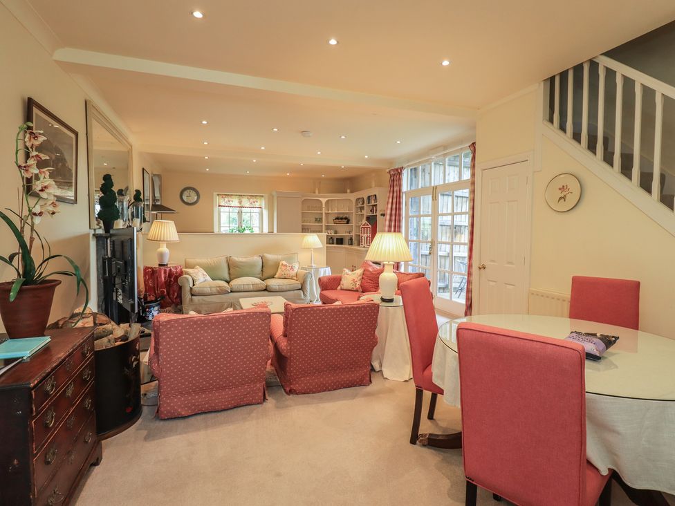 A living room with a sofa and dining area at The Garden Rooms Lawkland in Austwick