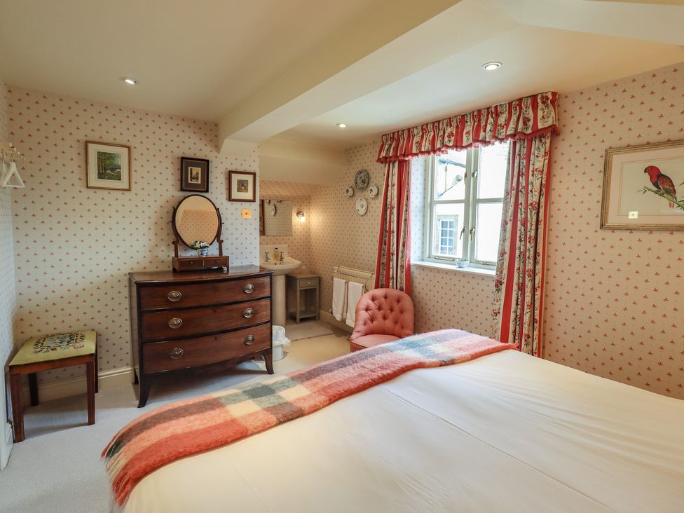 A bedroom with a bed, dressing table, and window at The Garden Rooms Lawkland Austwick
