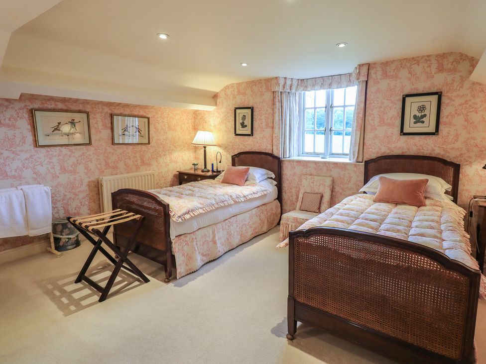 A bedroom with two beds and a window at The Garden Rooms Lawkland, Austwick