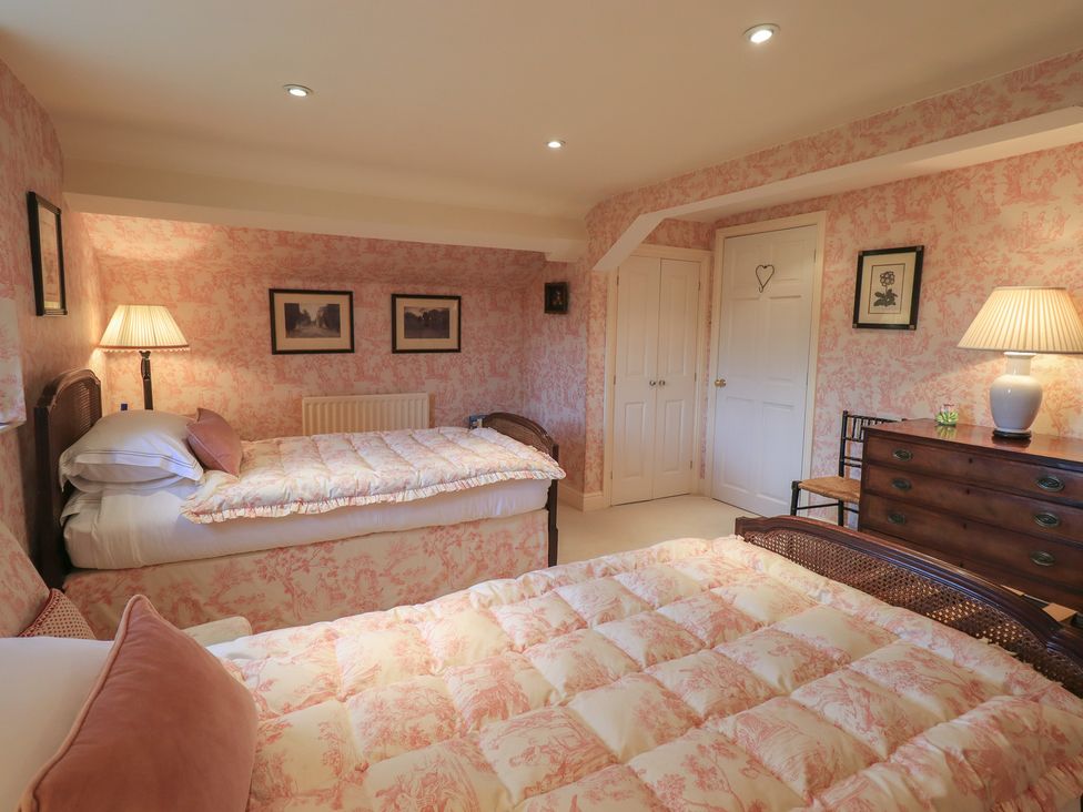 A bedroom with two beds and a lamp at The Garden Rooms Lawkland Austwick