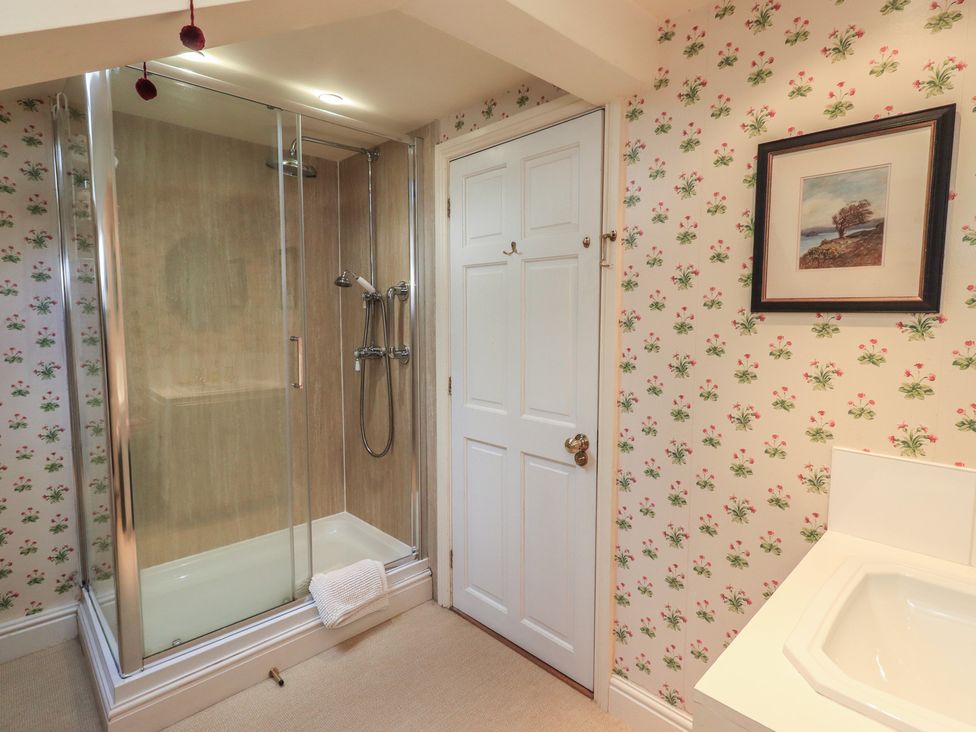 A bathroom with a shower and a door at The Garden Rooms Lawkland Austwick